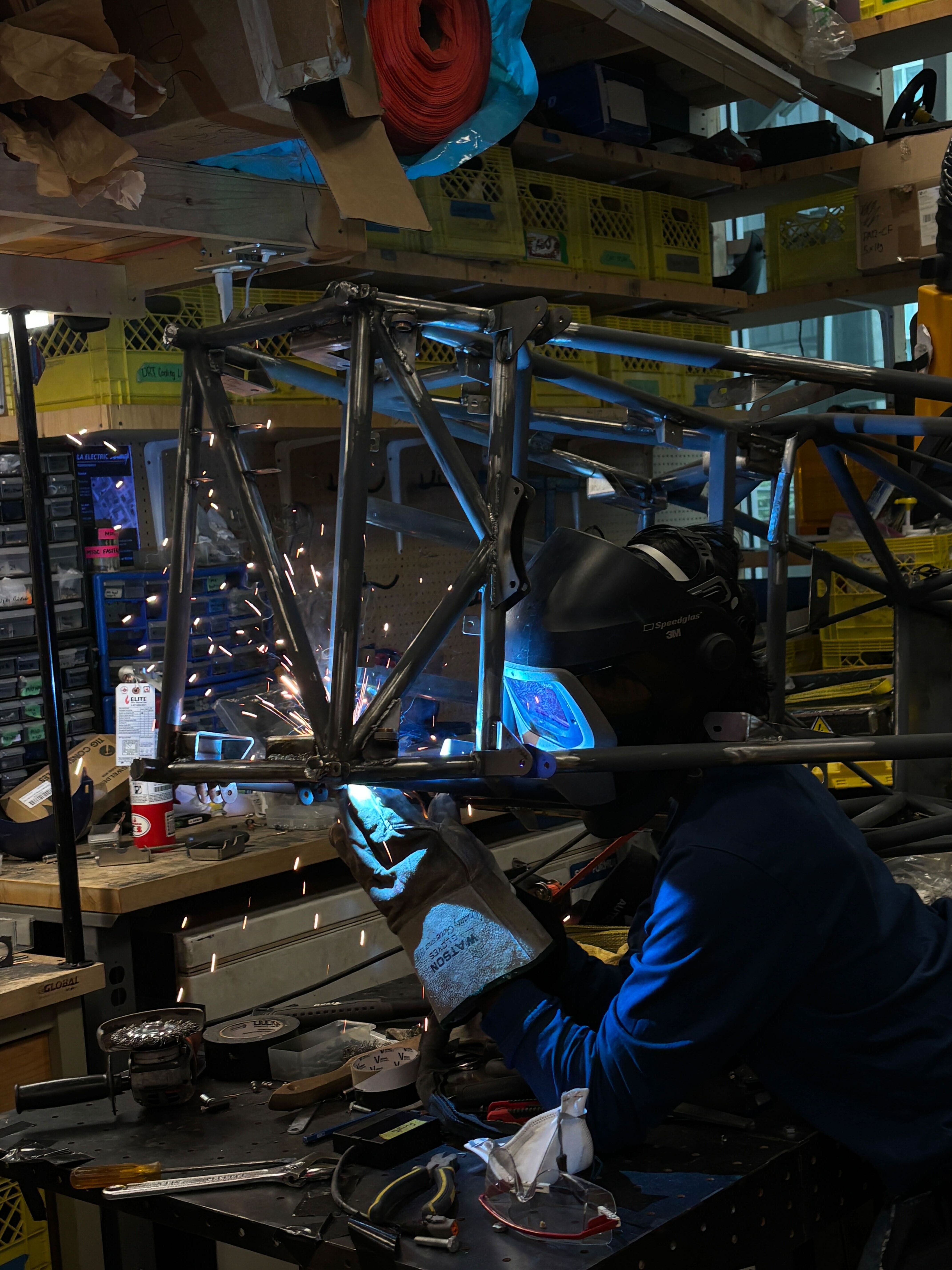 Daniel welding tractive-battery mounting tabs onto the chassis frame